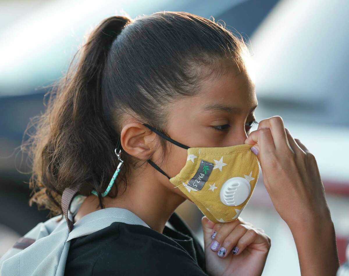 Zoey Gonzalez adjusts her mask before heading into Conroe ISD’s new Hope Elementary for the first day of school, Wednesday, Aug. 11, 2021, in Grangerland.