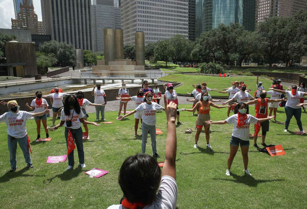 Vivianna Perez, who works on the outreach and advocacy team of Texas Freedom Network, front center, leads a demonstration against a new Texas law that bans abortions as early as six weeks into a pregnancy, on Wednesday, Sept. 1, 2021, at Tranquillity Park in Houston. The law also empowers private citizens to sue those who defy the law. “It’s going to make access to abortion nearly impossible, and it could potentially cause a domino effect,” Perez said of the new law.
