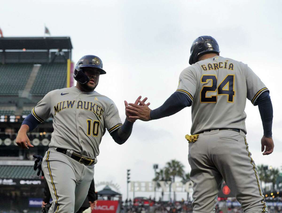 Avisail Garcia (24) high fives Omar Narvaez (10) after they scored on a Lorenzo Cain (6) single in the second inning as the San Francisco Giants played the Milwaukee Brewers at Oracle Park in San Francisco, Calif., on Wednesday, September 1, 2021.