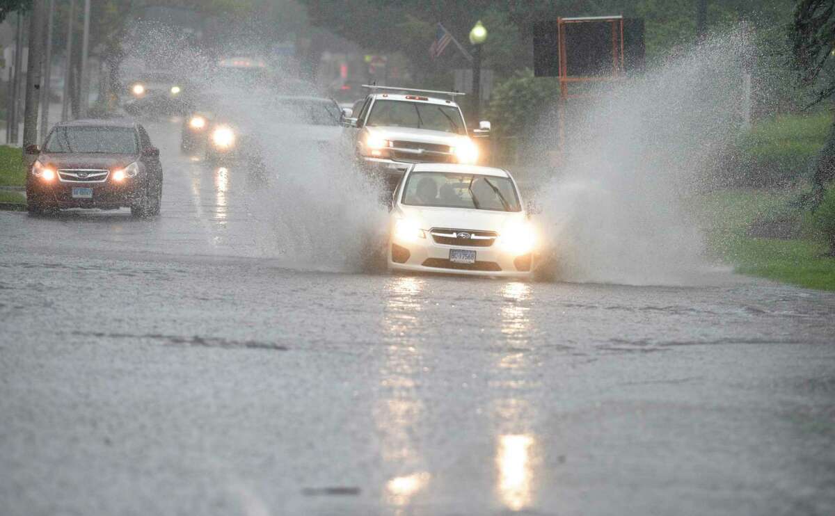 A car drives through flooded area on Main Street as the remnants of Tropical Depression Ida brought heavy rains to Danbury, Conn, Wednesday, Sept. 1, 2021.