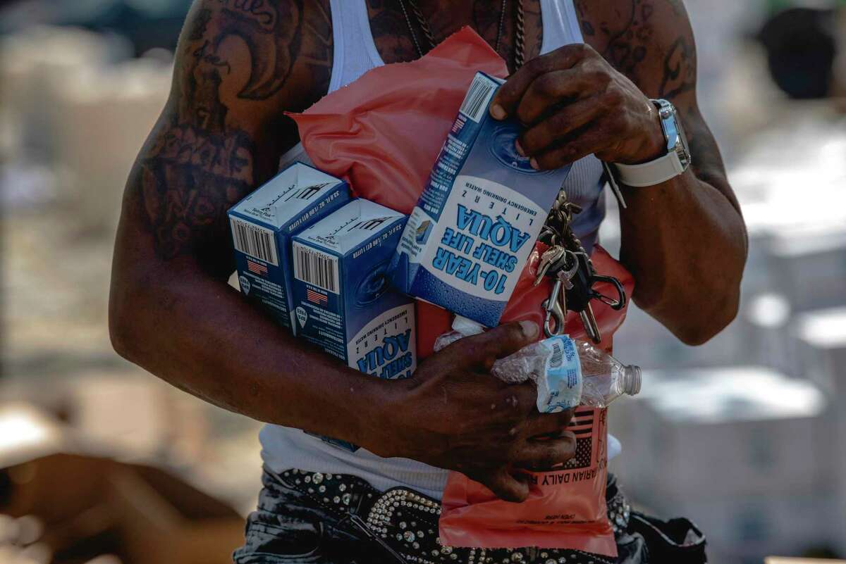 A person holds various boxed waters and military field rations at Treme Recreation Community Center in New Orleans on Wednesday, Sept. 1, 2021 as power outages continue due to the impacts of Hurricane Ida.