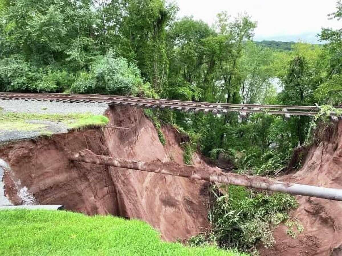 A massive sinkhole opened up near the 13th hole at the TPC River Highlands in Cromwell following storm Ida, leaving the railroad tracks in the air and a Buckeye natural gas pipeline exposed.