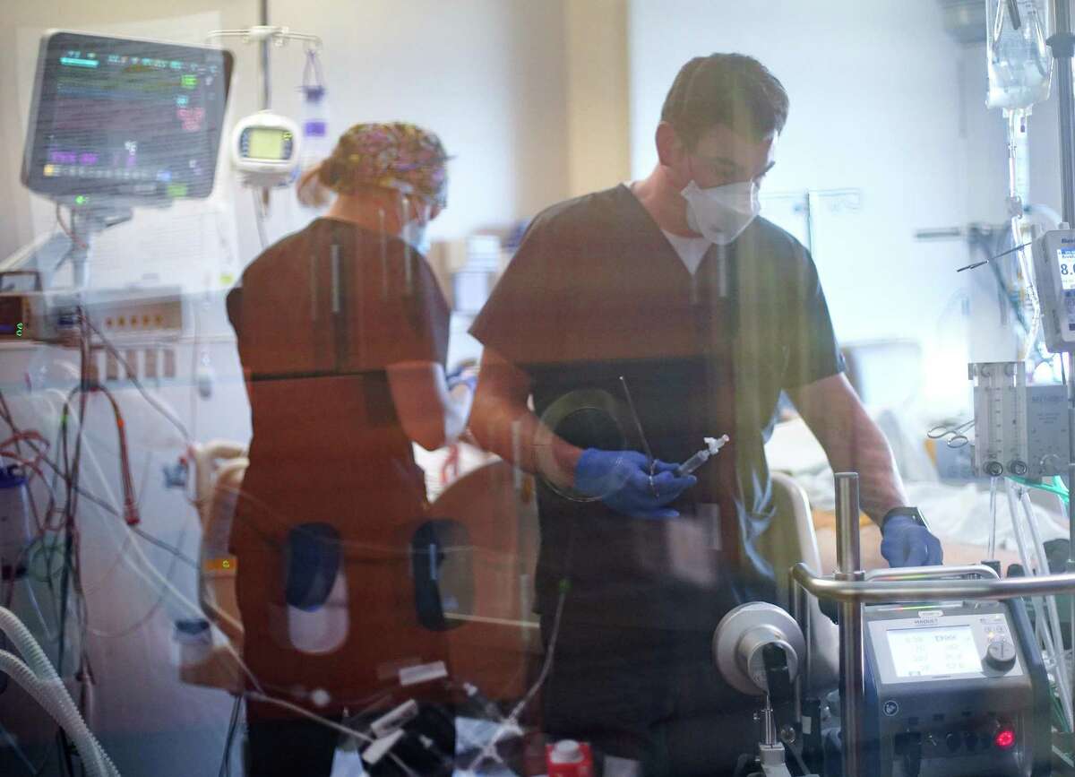Nurses work on a COVID-19 patient, who is in his 20's, at UTMB Galveston's ICU on Wednesday, Aug. 11, 2021.