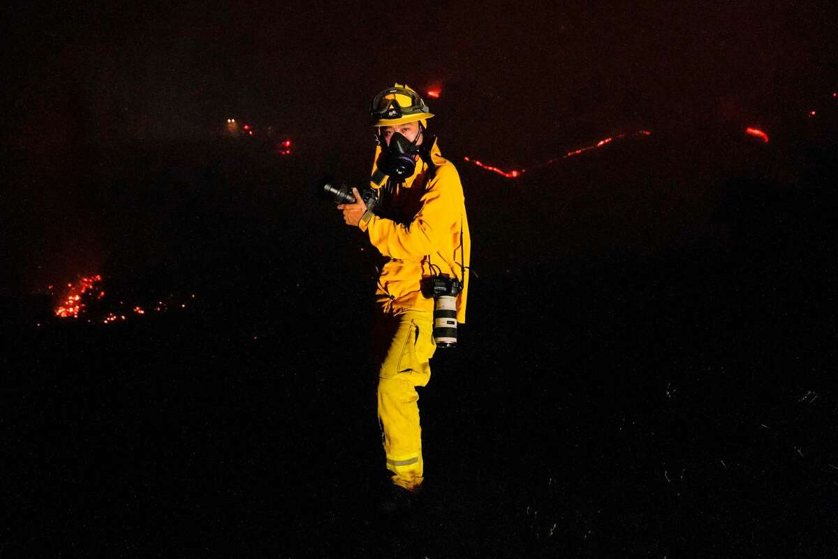 菲利普·帕切科(Philip Pacheco)于2020年9月28日星期一在加利福尼亚州圣罗莎(Santa Rosa)沿着山鹰大道(Mountain Hawk Drive)向房屋走去时拍摄了暗影大火。