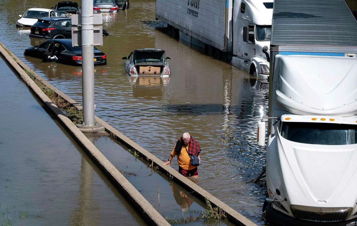 A person who eventually waded to a truck, moves amongst cars and other trucks that are stranded by high water Thursday, Sept 2, 2021, on the Major Deegan Expressway in Bronx borough of New York as high water left behind by Hurricane Ida still stands on the highway hours later.