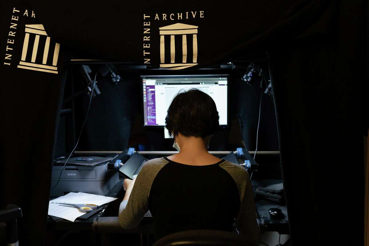 Book scanner Eliza Zhang, one of more than 100 employees, works at the offices of the Internet Archive in Richmond County.