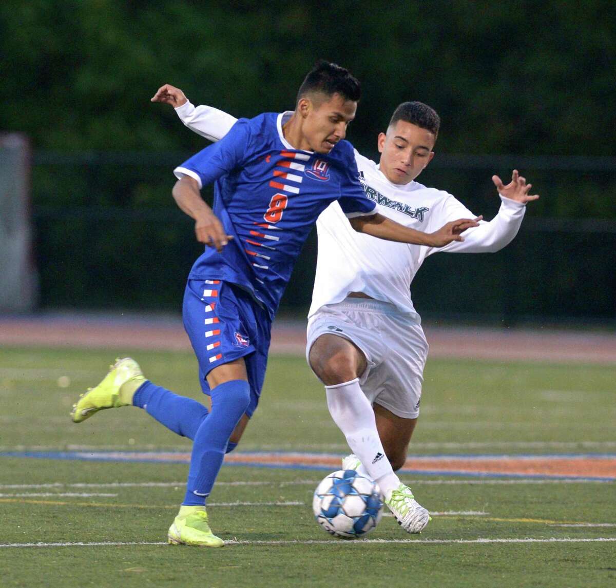 Danbury's Jeremy Garcia (8) and Norwalk's Mateo Cano (9) battle for the ball in the boys soccer game between Norwalk and Danbury high schools. Wednesday night, October 7, 2020, at Danbury High School, Danbury, Conn.