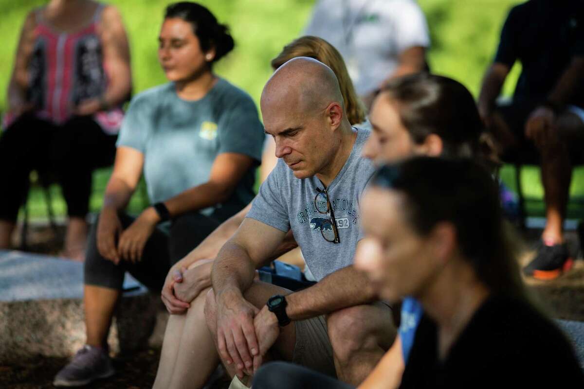 A group of people learn about mindfulness and meditation as part of Grounding with the Trees at Buffalo Bayou Park, Saturday, Sept. 4, 2021, in Houston. The practice is inspired by Forest Bathing movements in South Korea and Japan. The lesson was led by Heather Sullivan, a mindfulness instructor.