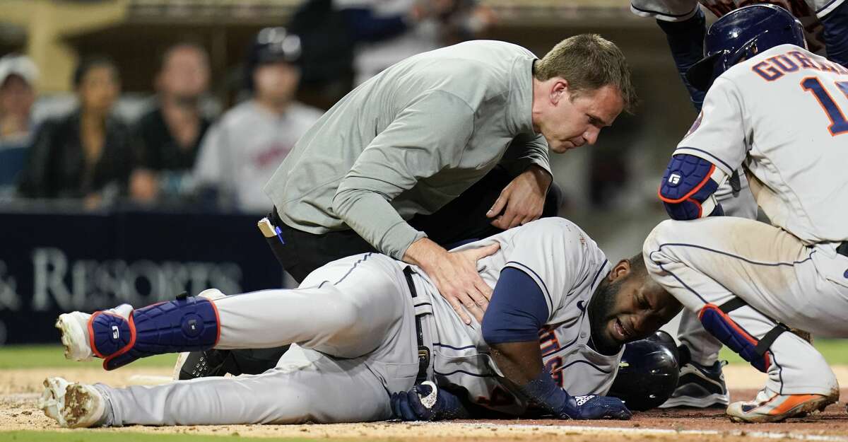 Houston Astros' Yordan Alvarez, below, reacts after getting hit by a foul ball while batting during the fifth inning of a baseball game against the San Diego Padres, Saturday, Sept. 4, 2021, in San Diego. (AP Photo/Gregory Bull)