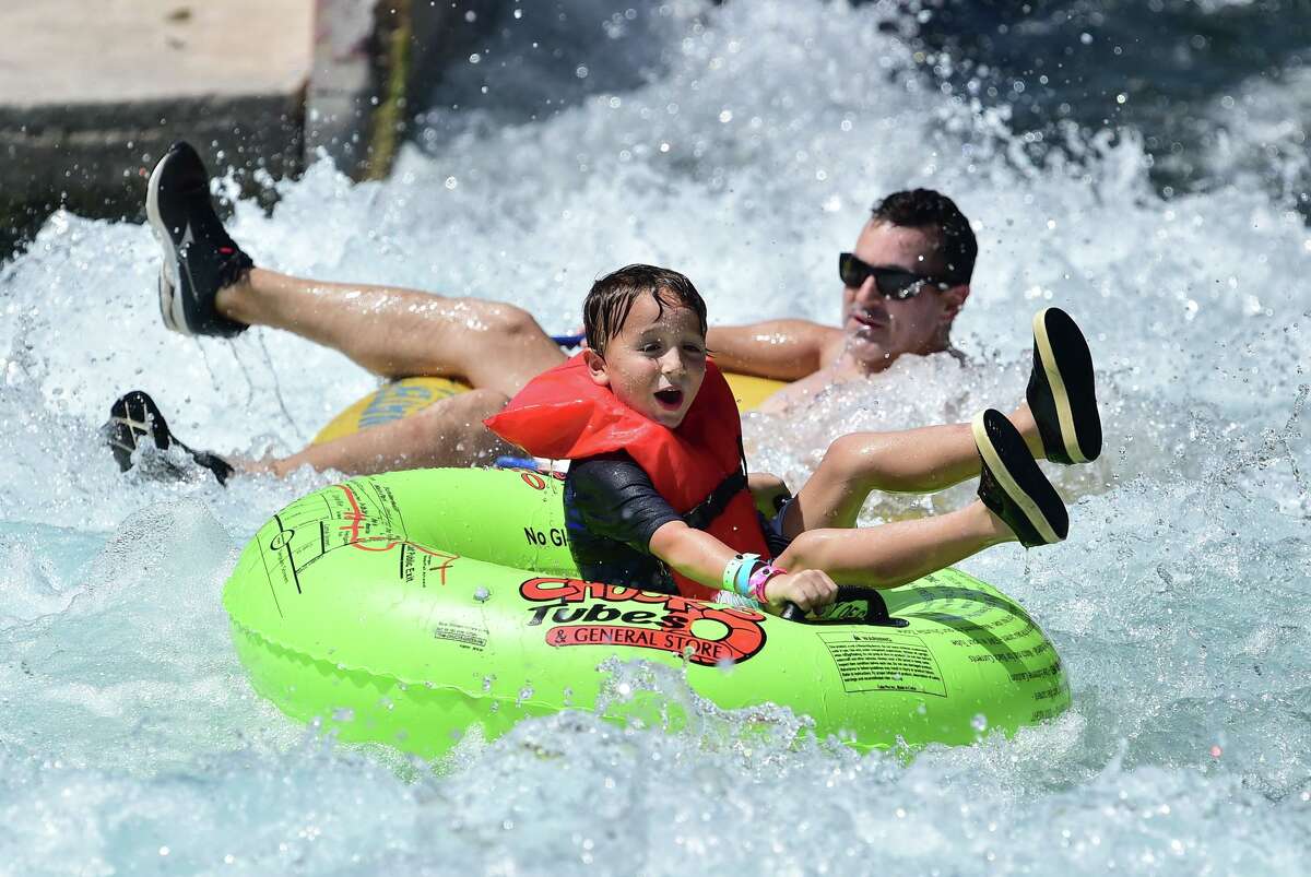A youngster laughs as he bounces through the tube chute on the Comal River in New Braunfels.