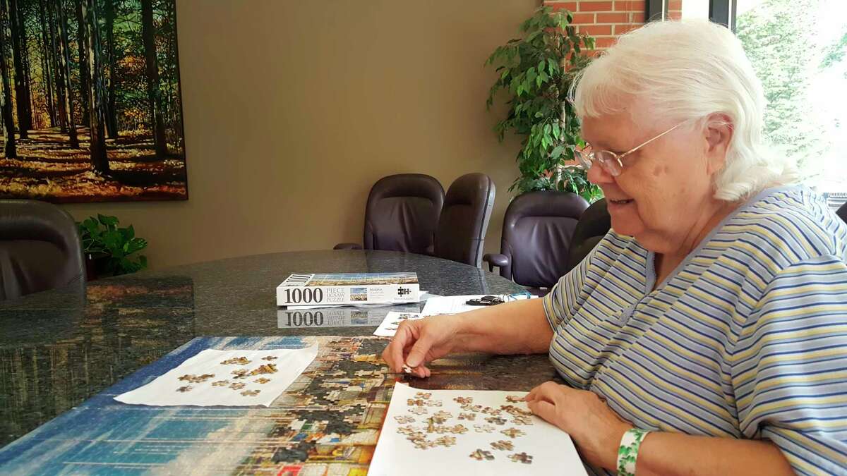 Mary Myers, 80, of Midland, works on a jigsaw puzzle during a recent visit to the Greater Midland Community Center. (Photo by Dave Shane/For the Daily News)