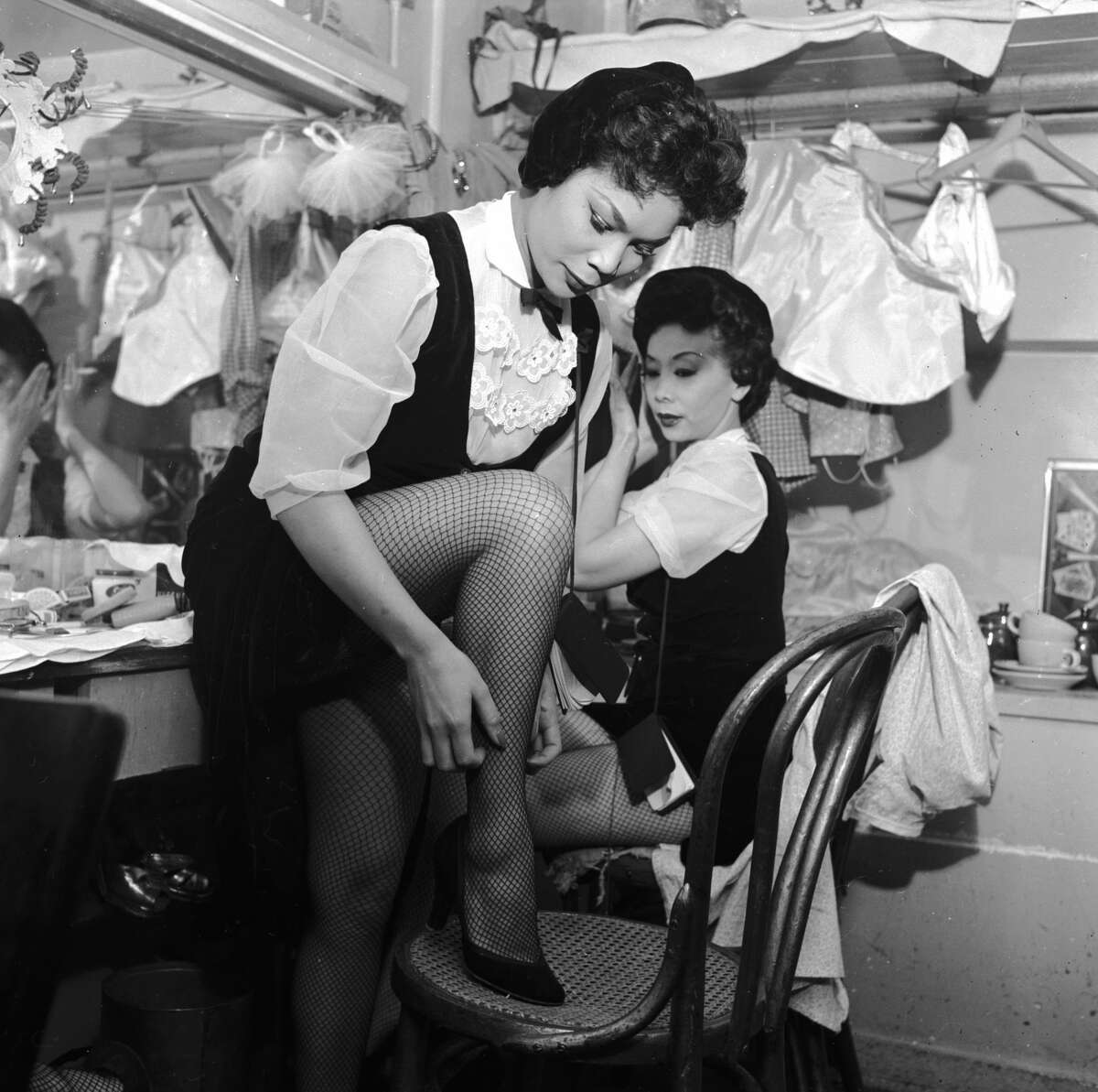 Two chorus girls prepare for their act in the dressing room of the Forbidden City nightclub circa 1955 in Chinatown, San Francisco. 