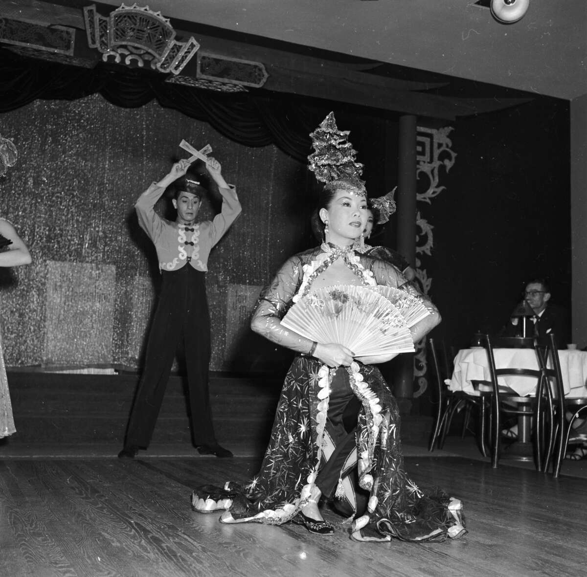 Chinese dancers Mae Tai Sing and Tony Wing perform an elaborate floor show circa 1955 at Forbidden City, a nightclub in Chinatown, San Francisco.