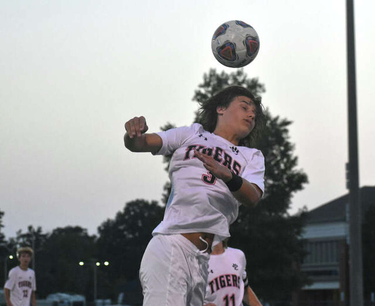 Edwardsville’s Tyler Dacus leaps high to attempt a header during the first half against Belleville East on Tuesday in Belleville.