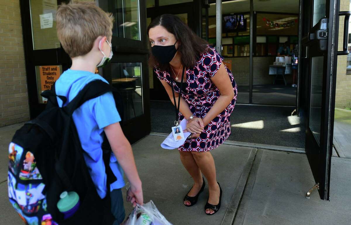 Students are greeted by staff including principal Andrea D’Auito as they arrive for their first day of class at Long Hill Elementary School on Wednesday in Shelton.