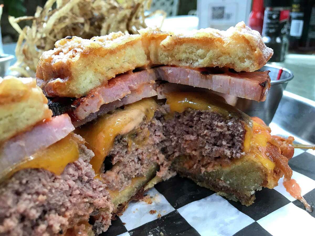 The Monte Cristo Burger AKA Doc Holliday features a half-pound beef patty, slabs of griddled ham and cheese on a crispy fried bun.