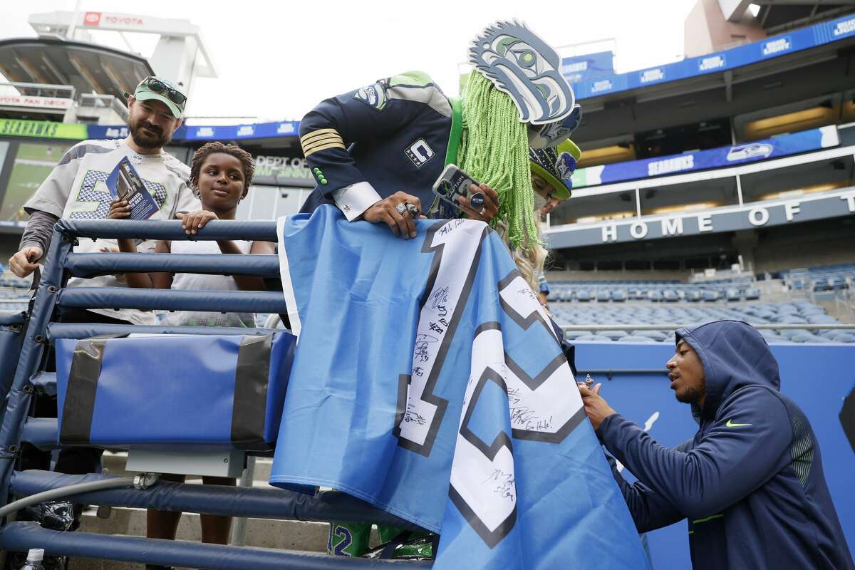 SEATTLE, WASHINGTON - AUGUST 21: Wide receiver Tyler Lockett # 16 of the Seattle Seahawks signs autographs prior to an NFL preseason game against the Denver Broncos at Lumen Field on August 21, 2021 in Seattle, Washington.  The Denver Broncos beat the Seattle Seahawks 30-3.  (Photo by Steph Chambers / Getty Images)
