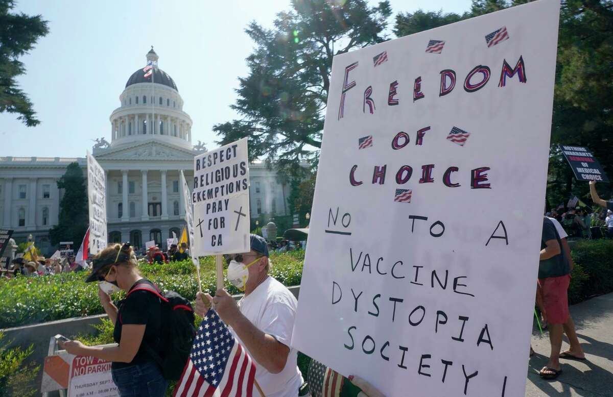 Protesters opposing vaccine mandates, which could be advanced again next year, march past the Capitol.