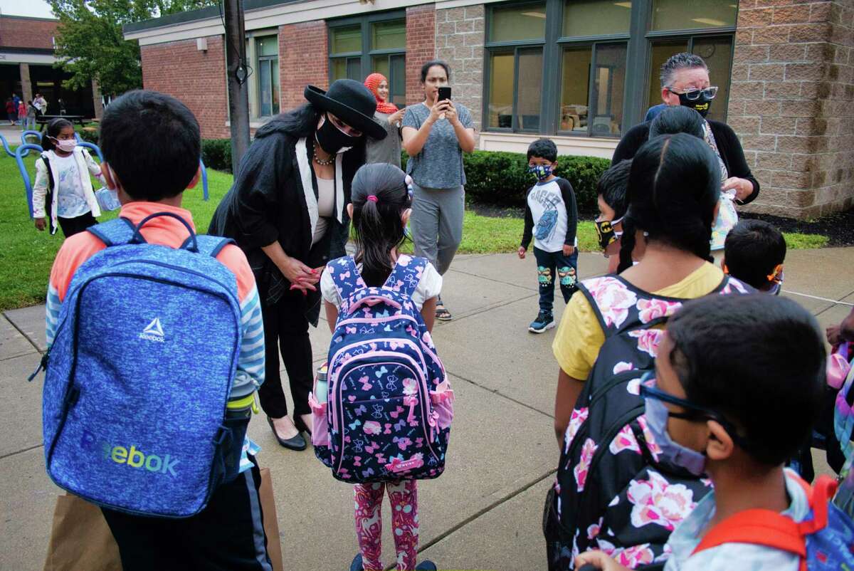 New York State Education Commissioner Betty Rosa, left, and Maureen Long, right, Menands School District superintendent, greet students arriving at Menands School on the first day of classes on Thursday, Sept. 9, 2021, in Menands, N.Y.
