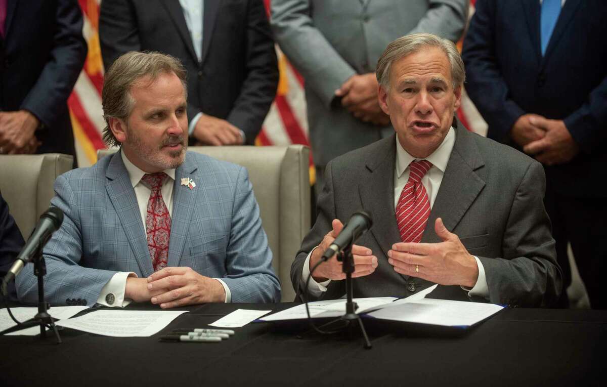 Texas Governor Greg Abbott and state Sen. Bryan Hughes celebrate Senate Bill 1 in September. Now counties are rejecting mail ballot applications.