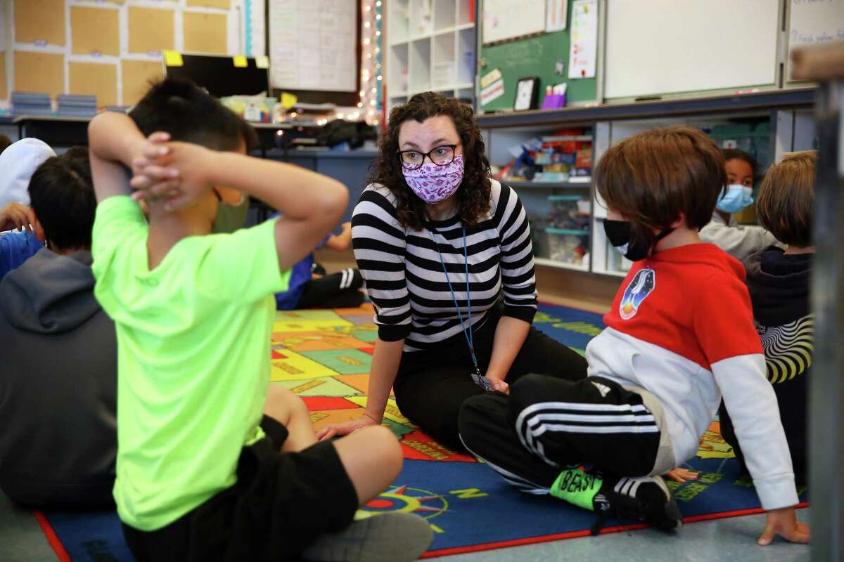 In this July 2021 file photo, Fourth grade teacher Erin Flathers (center) talks with fourth grade students as they work in pairs during a morning class exercise in the classroom. San Francisco school saw a significant drop in enrollment this year, losing 2,552 students, or nearly 5%.