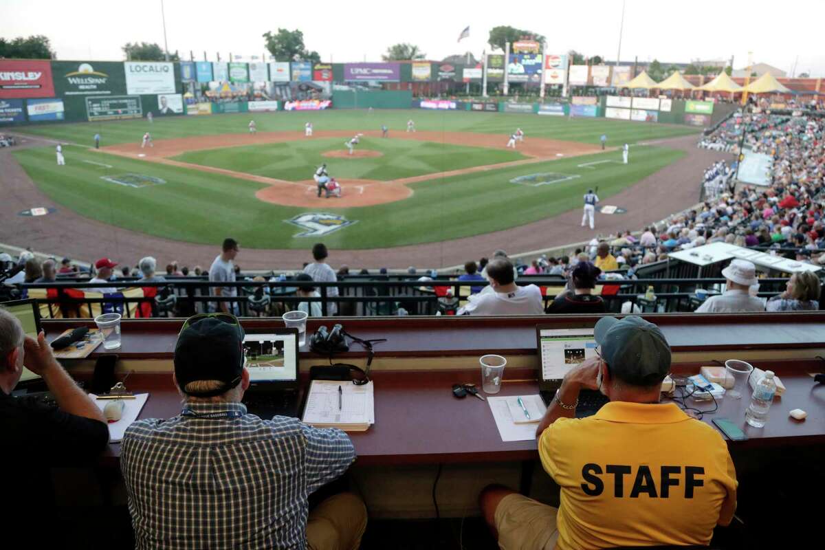 Ron Besaw, right, operates a laptop computer as home plate umpire Brian deBrauwere, gets signals from radar with the ball and strikes calls during the fourth inning of the Atlantic League All-Star minor league baseball game, Wednesday, July 10, 2019, in York, Pa. deBrauwere wore an earpiece connected to an iPhone in his ball bag which relayed ball and strike calls upon receiving it from a TrackMan computer system that uses Doppler radar. The independent Atlantic League became the first American professional baseball league to let the computer call balls and strikes during the all star game. (AP Photo/Julio Cortez)