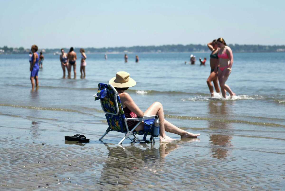 People relax on the beach at Greenwich Point Park in Old Greenwich, Conn. Wednesday, June 30, 2021.