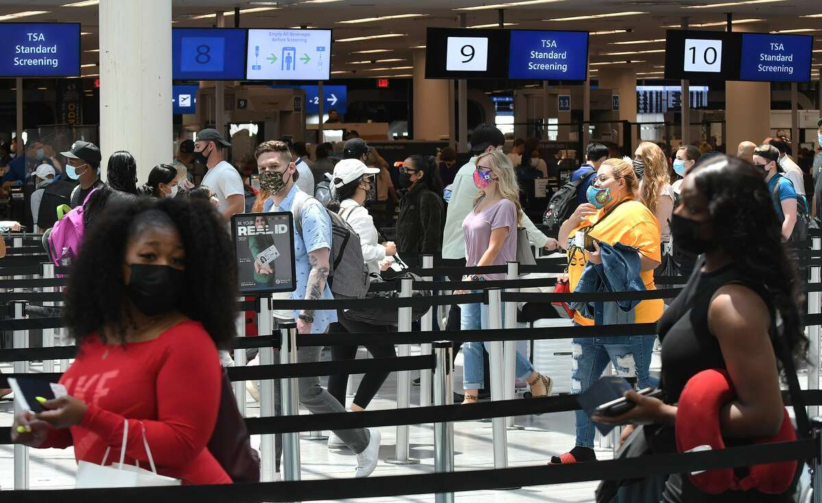 FILE - Travelers wait in line at a Transportation Security Administration screening checkpoint at Orlando International Airport on the Friday before Memorial Day. (Photo by Paul Hennessy/SOPA Images/LightRocket via Getty Images)