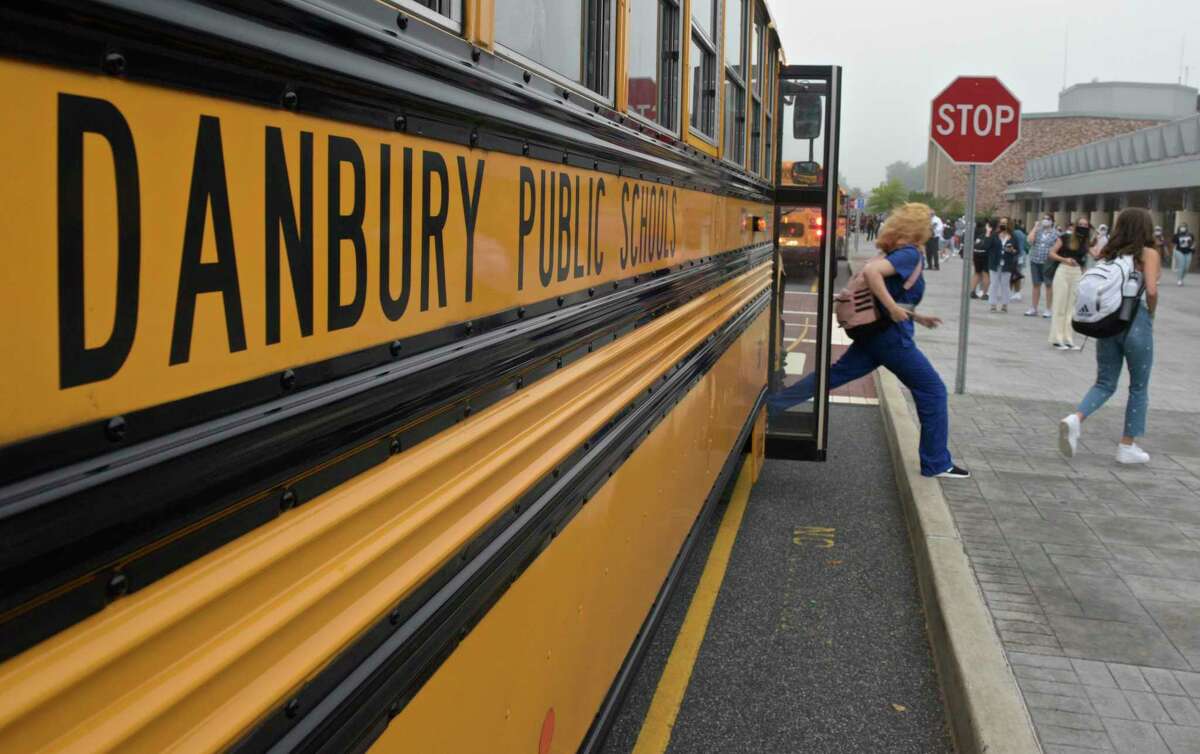 Students get of the buses at Danbury High School on the first day of the new school year. Monday, August 30, 2021, in Danbury, Conn.