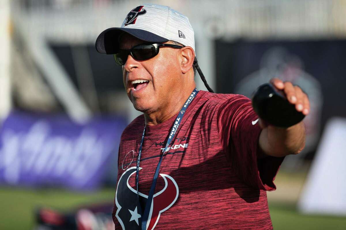 Houston Texans head coach David Culley waves at fans as his players warm up during an NFL training camp football practice Saturday, Aug. 7, 2021, in Houston.