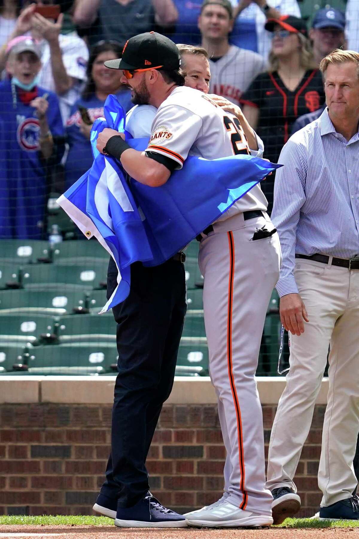 Chicago Cubs owner Tom Ricketts, left, embraces San Francisco Giants' Kris Bryant before a baseball game in Chicago, Friday, Sept. 10, 2021. (AP Photo/Nam Y. Huh)