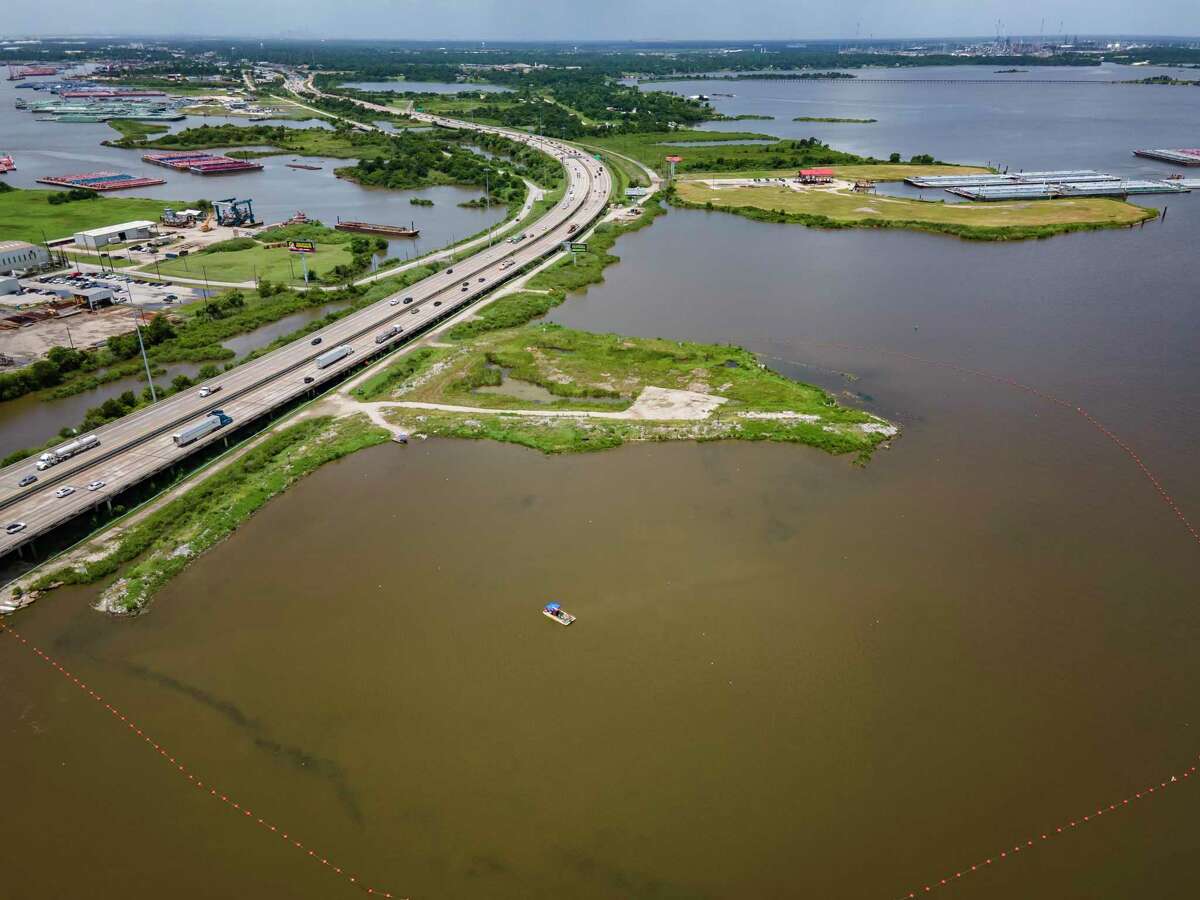 A line of buoys marks the boundary of the northern impoundments of the San Jacinto Waste Pits just north of Interstate 10 on the San Jacinto River, Tuesday, July 13, 2021, in Channelview. The southern impoundments of the superfund site are on the small peninsula south of the freeway.
