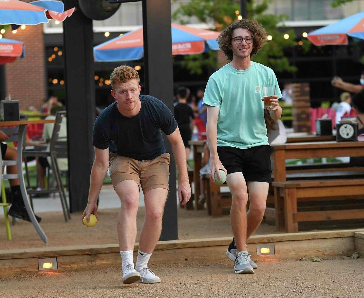 Brothers Kevin, left, and Derek Gay play a game of bocce at Chicken N Pickle. Typically the sport of elderly Italian men, bocce is growing in popularity among a younger demographic.
