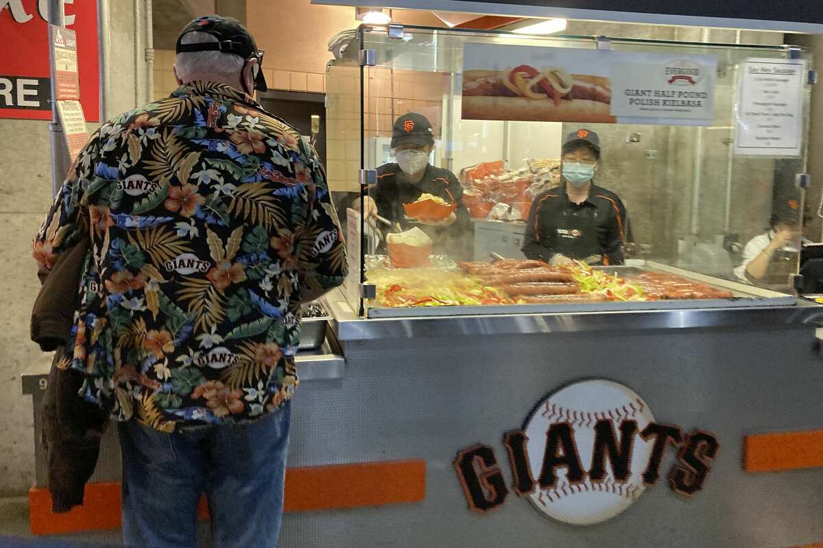 A fan buys food from a vendor at Oracle Park before a baseball game between the Giants and the Los Angeles Dodgers in San Francisco, Sunday, Sept. 5, 2021.