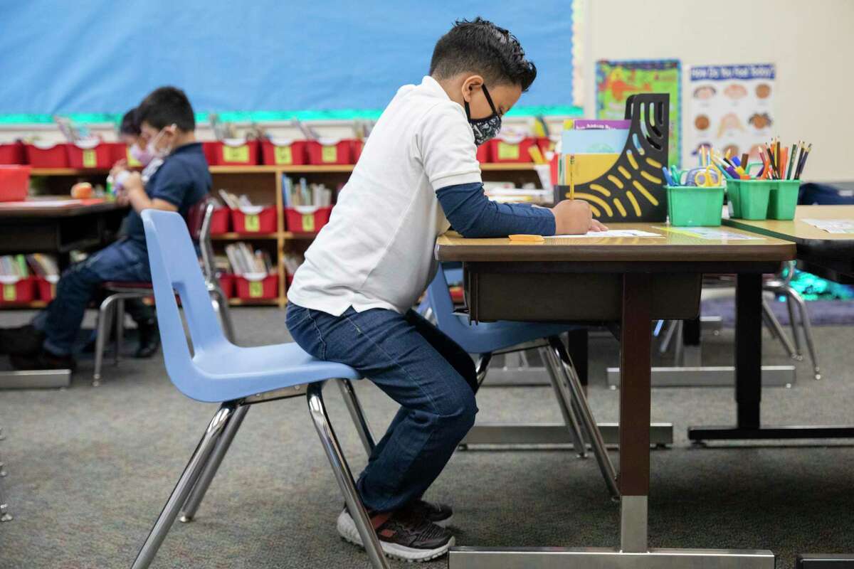 A second-grade student wears a mask while working on a project at Garfield Elementary School in Oakland.