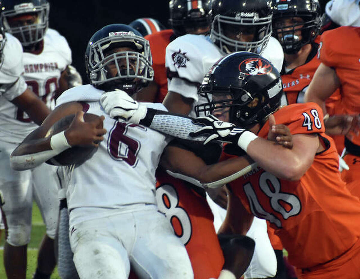 Edwardsville’s Wyatt Kolnsberg and Nasim Cairo (not pictured) combine to make a tackle against Champaign Central in the first quarter on Friday in Edwardsville.