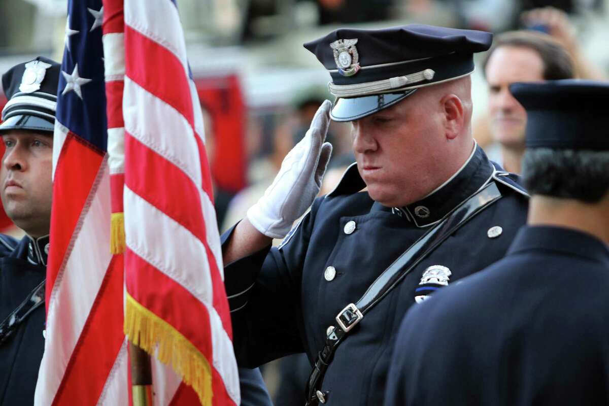 A member of the Greenwich Police Department Honor Guard salutes the U.S. flag during Glenville Volunteer Fire Company's ceremony to commemorate the 20th anniversary of 9/11 in Greenwich, Conn., on Friday September 10, 2021.