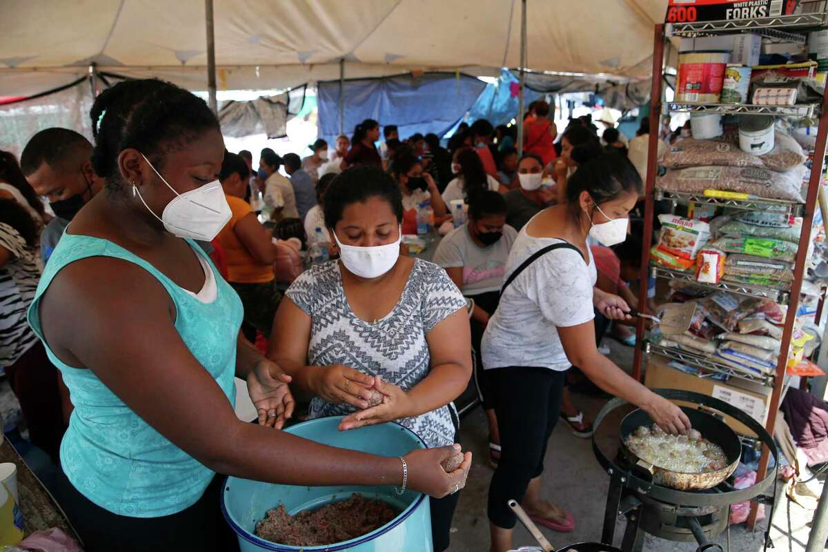 Migrant women cook food July 26 for a crowd camped out at Plaza de la Republica in Reynosa, Mexico. The U.S. is still enforcing Title 42 travel restrictions/