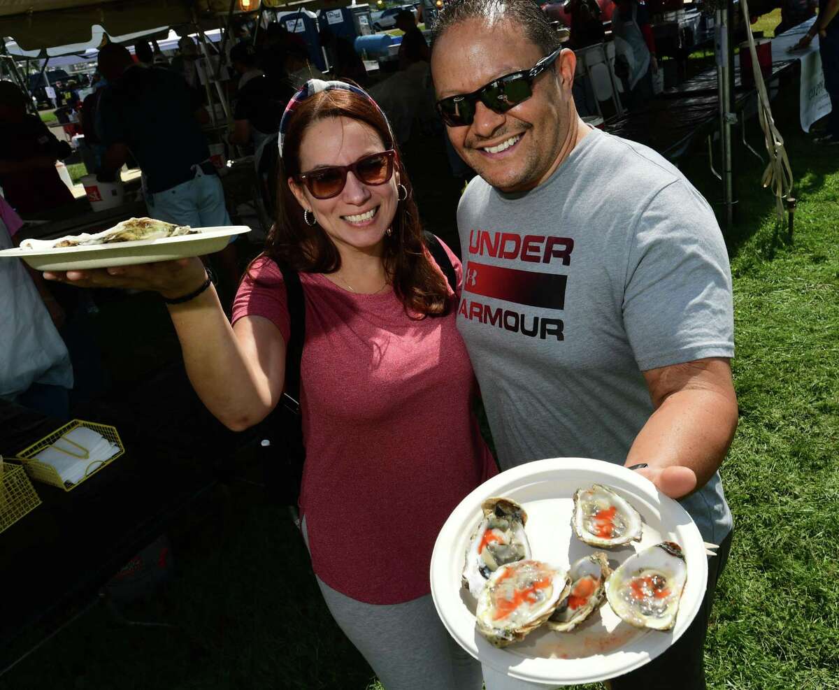 Jenny Melendez and Martin Cabassa enjoy oysters from the Coast GUard Auxiallry booth during the 43rd Annual Norwalk Oyster Festival Saturday, September 11, 2021, at Veterans Memorial Park in Norwalk, Conn.