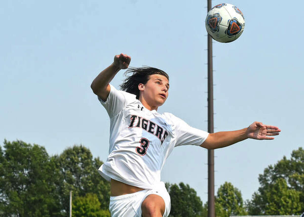 Edwardsville’s Tyler Dacus attempts a header during the first half against Marquette Catholic last season in Alton.