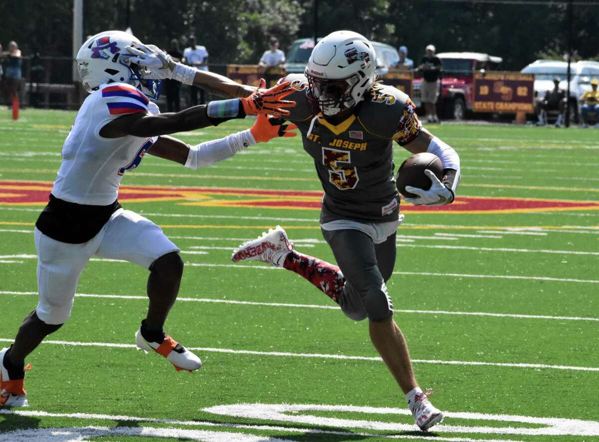 St. Joseph’s Maxwell Warren breaks a tackle against Danbury on Saturday in Trumbull.