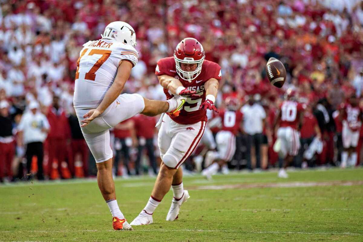 Cameron Dicker of Texas has his punt blocked in the first half by Jake Yurachek (25) of Arkansas during Saturday’s game at Fayetteville.