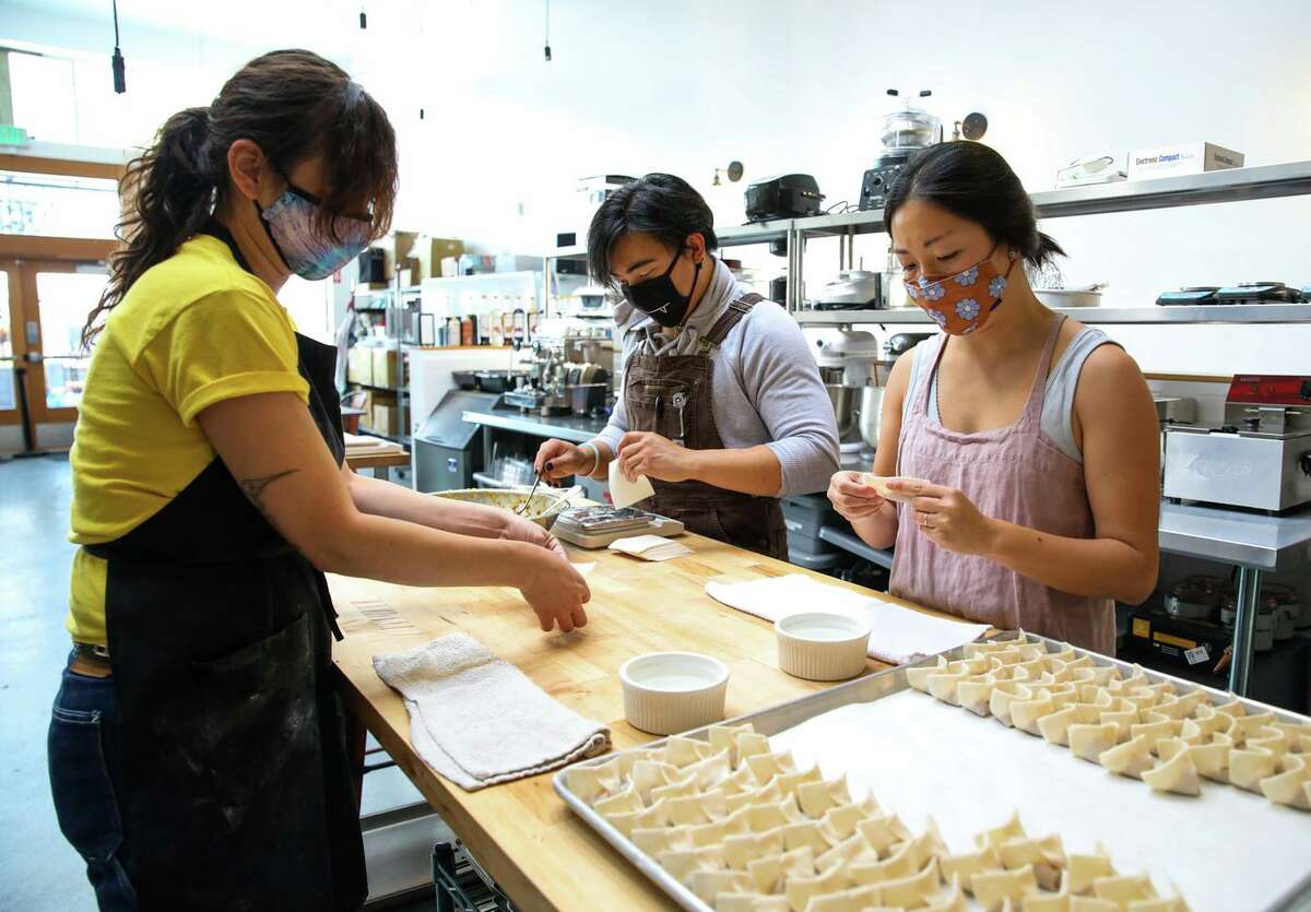 Nikki Munoz (left), Htet and Cathay Bi, owner of Dumpling Club, work in a commercial kitchen in San Francisco. Bi closed the business in August to give herself and her staff time off.