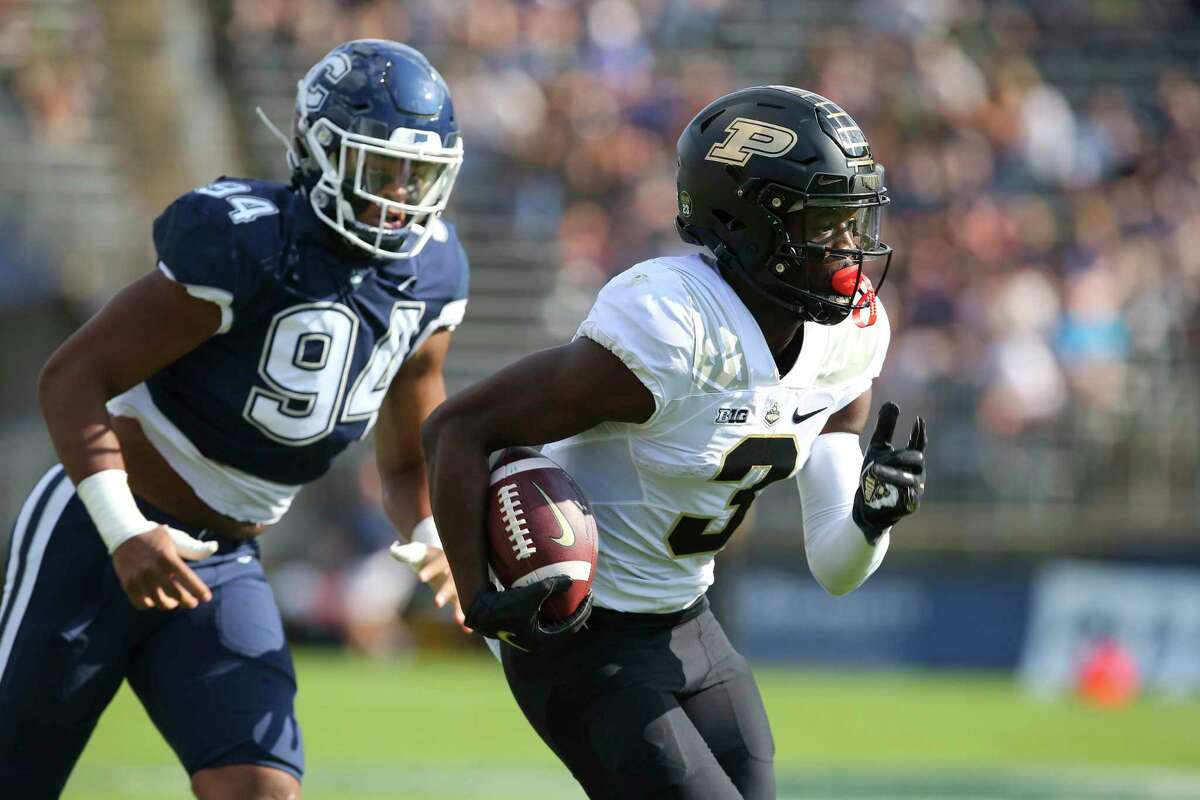 Purdue wide receiver David Bell (3) is pursued by Connecticut defensive lineman Nick Harris (94) during the first half of an NCAA football game on Saturday, Sept. 11, 2021, in East Hartford, Conn. (AP Photo/Stew Milne)