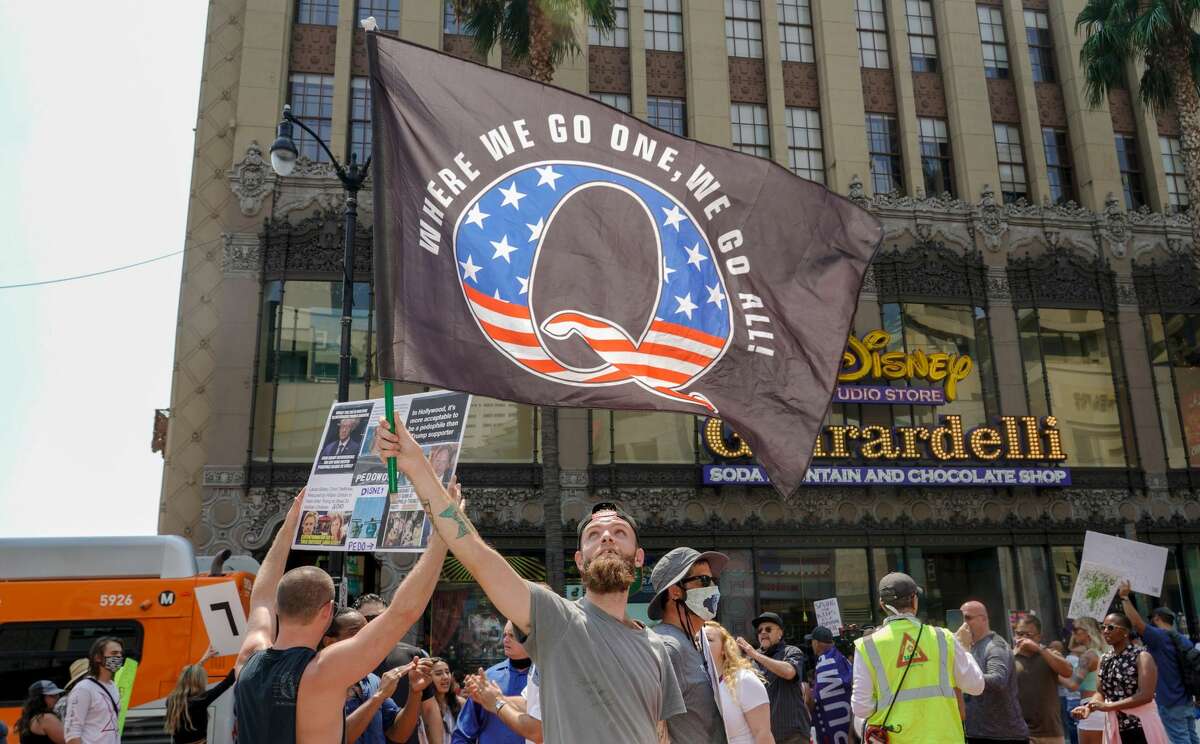 A man waves a Q flag at a rally against child trafficking on Hollywood Boulevard in Los Angeles on Aug. 22, 2020. QAnon believers often launder their more extreme beliefs by claiming they are trying to "save the children" from what they imagine is rampant sex trafficking.