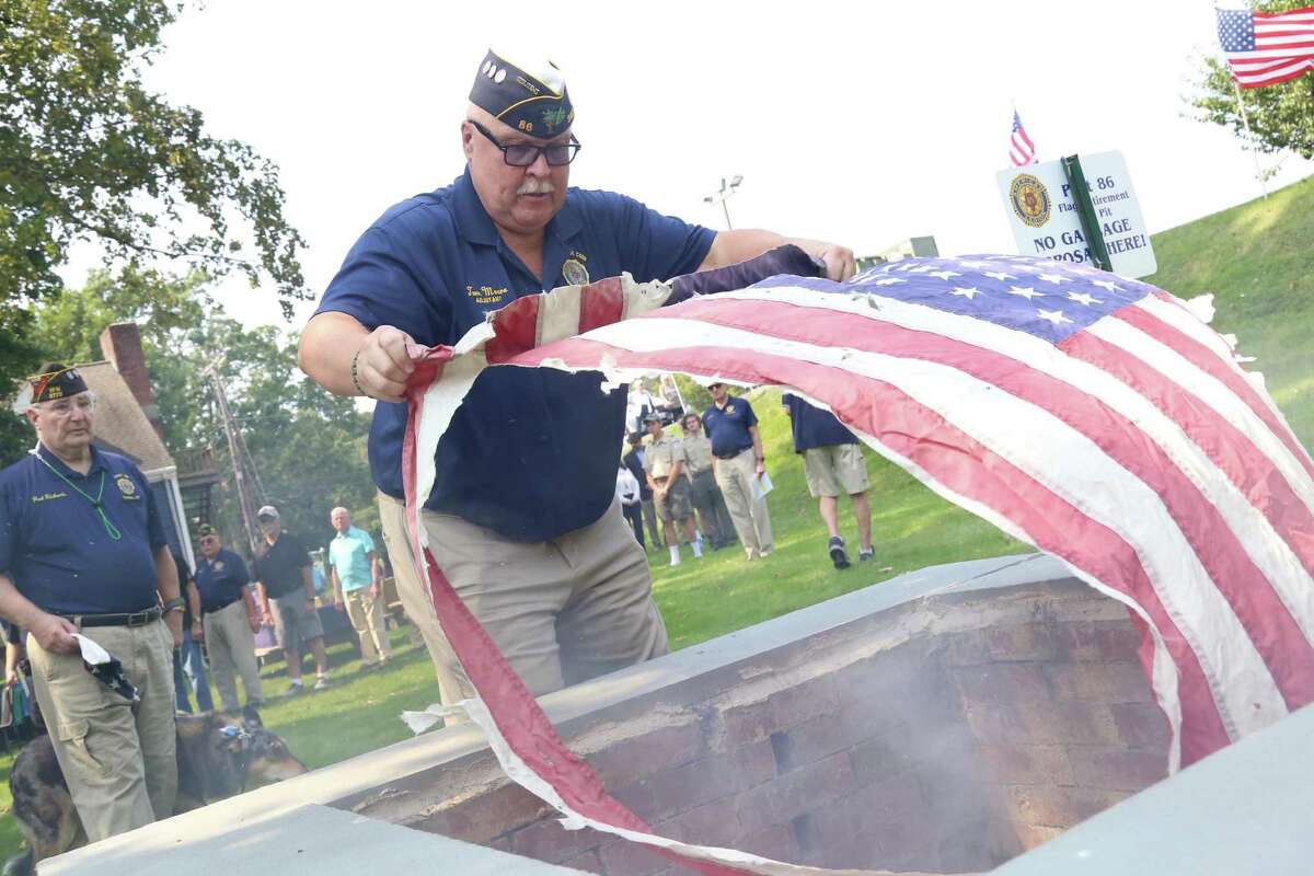 Tom Moore, post adjutant, lays a tattered flag to rest.