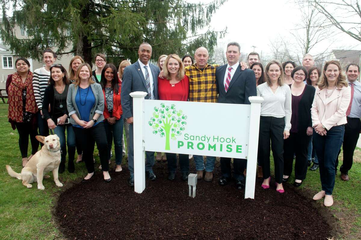 Robert Fuller, right, Assistant Special Agent in Charge of the FBI's New Haven Field Office and Charles Grady, left, an FBI Community Outreach Specialist, stand with Nicole Hockley, Mark Barden and others from Sandy Hook Promise in Newtown. April 8, 2019. Sandy Hook Promise were presented with the FBI Director's Community Leadership Award.