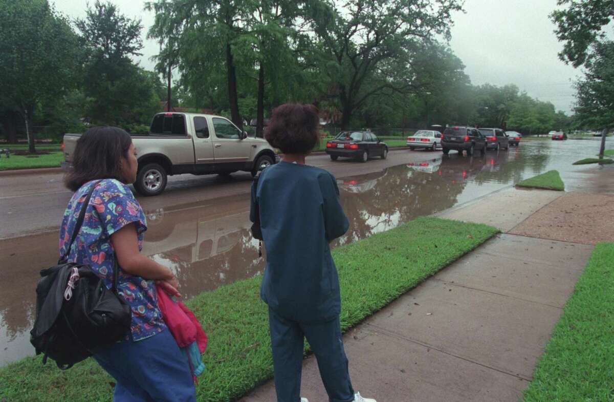 CONTACT FILED: TROPICAL STORM-ALLISON THE GREAT FLOOD OF 2001 -- Daisy Burgos, RN, left, an employee of Texas Children's Hospital and Phongchan Schill, RN, an employee of the VA Hospital, wait for the water to recede on Bellaire Blvd. so they can get to the medical center to work. Bellaire Blvd. is flooded due to heavy rain from tropical storm Allison on 06/09/01. Residents are hoping there’s no repeat with Tropical Storm Nicholas.