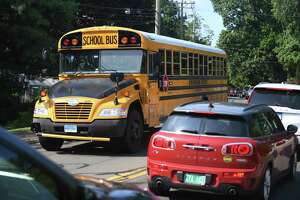 Traffic is backed up as buses pick up students during dismissal at Brien McMahon High School in Norwalk, Conn. Monday, Sept. 13, 2021. Since students returned to school, traffic at arrival and dismissal has caused significant backups in the area.