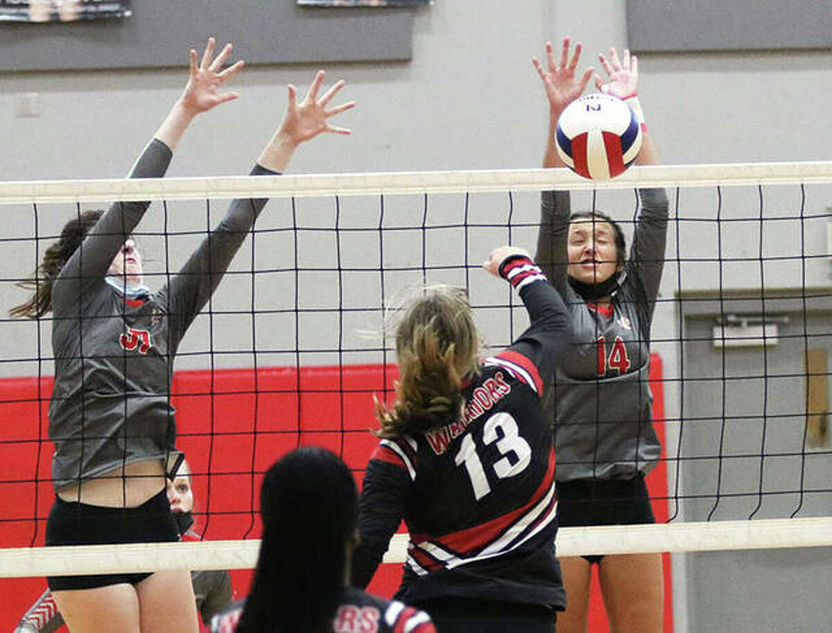 Alton’s Grace Carter (right) scores off a block of the attack from Granite City’s Emily Sykes (13) while the Redbirds’ Reese Plont (left) also goes above the net during a third-place match Saturday at the Alton Invite.